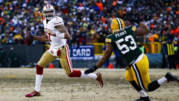 Ein Quarterback der San Francisco 49ers läuft mit dem Ball, verfolgt von einem Spieler der Green Bay Packers.