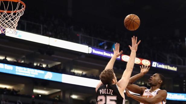 Zwei Basketballspieler kämpfen um den Ball während eines Spiels.