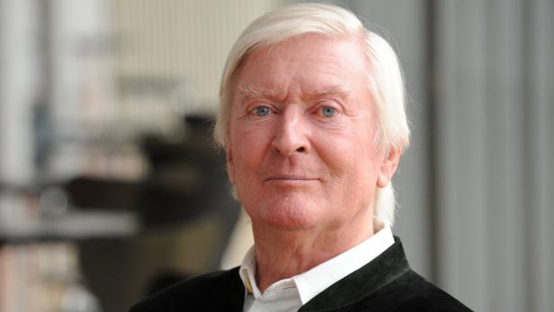 Ein Porträt eines älteren Mannes mit weißen Haaren und blauen Augen.