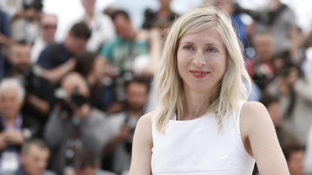 Die Schauspielerin Sandra Hüller lächelt vor einer Menschenmenge.