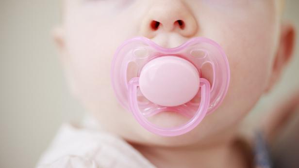 Close up of baby with pink pacifier
