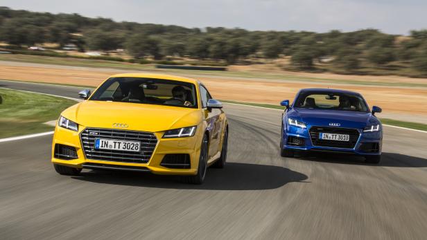 Ein gelber und ein blauer Audi TT fahren auf einer Rennstrecke.