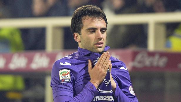 Ein Fußballspieler im lila Trikot der Fiorentina mit gefalteten Händen.