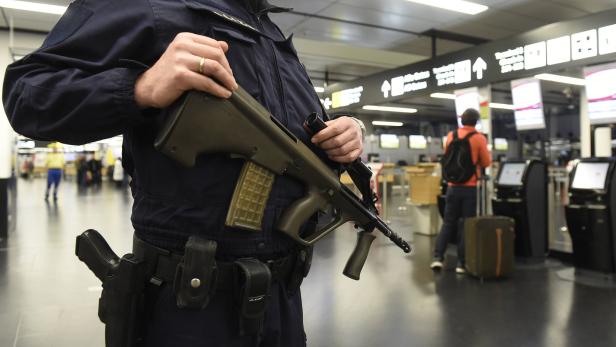 Ein bewaffneter Sicherheitsbeamter patrouilliert in einem Flughafen.