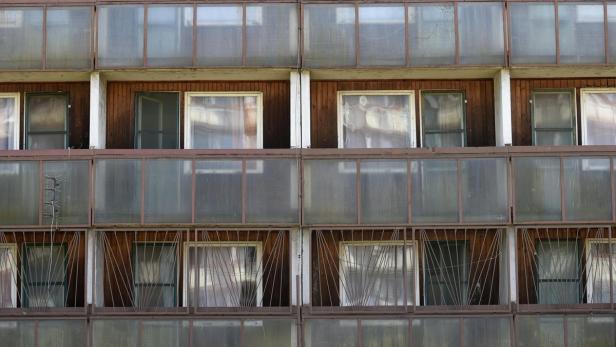 Die Fassade eines mehrstöckigen Gebäudes mit Fenstern und Balkonen.