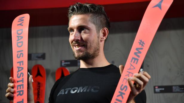 Ein Mann hält zwei Atomic-Ski mit den Aufschriften „My Dad is faster than you“ und „#WEARESKIING“.