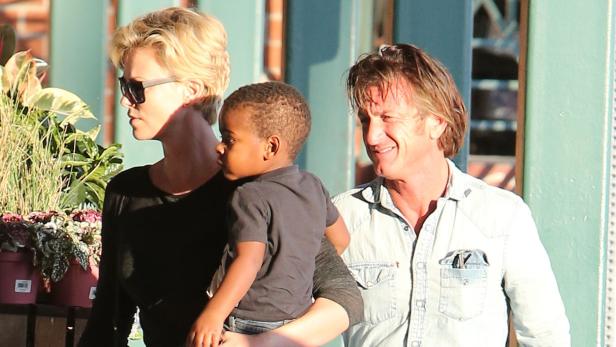 Charlize Theron und Sean Penn mit einem Kind im Arm.