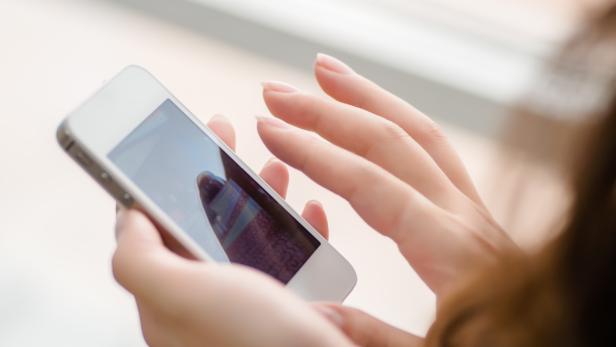 Eine Frau bedient ein Smartphone mit ihren Händen.