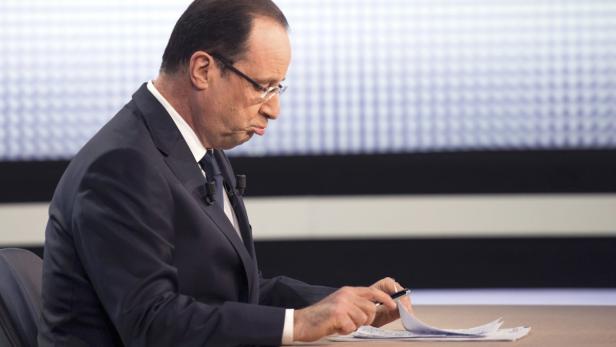 France&#039;s President Francois Hollande studies his notes before appearing on France 2 television prime time news broadcast for an interview at their studios in Paris, March 28, 2013. President Hollande will answer questions about the state of the French economy and high unemployment in his first such televisied appearance in several months. REUTERS/Fred Dufour/Pool (FRANCE - Tags: POLITICS)