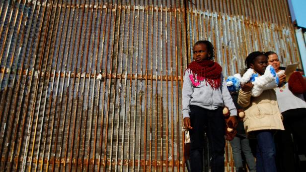 Das Foto stammt aus 2016 und zeigt Menschen auf der mexikanischen Seite des Metallzaunes an der Grenze zu den USA.