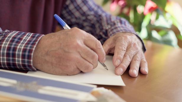 old man writing christmas cards