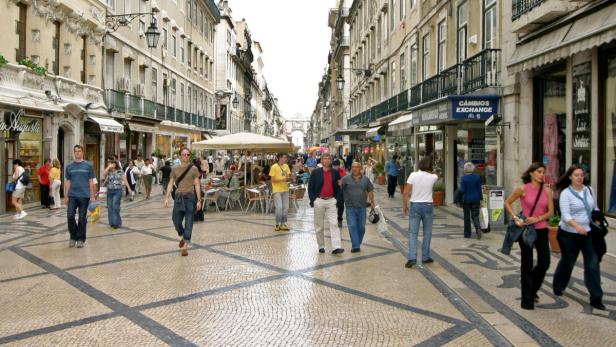 Menschen flanieren auf der belebten Rua Augusta in Lissabon.