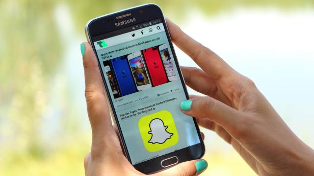 Eine Person hält ein Samsung-Smartphone mit der Snapchat-App in der Hand.