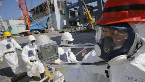 A radiation monitor indicates 114.00 microsieverts per hour near the No.4 reactor (background C) and it&#039;s foundation construction (background R) for the storage of melted fuel rods at Tokyo Electric Power Co. (TEPCO)&#039;s tsunami-crippled Fukushima Daiichi nuclear power plant in Fukushima prefecture, March 6, 2013, ahead of the second-year of anniversary of the the March 11, 2011 tsunami and earthquake. Members of the media were allowed into the plant on Wednesday ahead of the second-year anniversary of the tsunami and earthquake, which triggered the world&#039;s worst nuclear crisis since Chernobyl. REUTERS/Issei Kato (JAPAN - Tags: DISASTER ANNIVERSARY ENERGY)