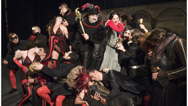Eine Gruppe von Schauspielern in Kostümen auf einer Theaterbühne.