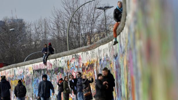Menschen besuchen die East Side Gallery, ein erhaltenes Teilstück der Berliner Mauer.