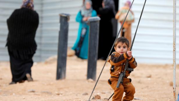A Syrian refugee child plays before the arrival of actor Angelina Jolie, UNHCR Special Envoy, at the Al Zaatri refugee camp