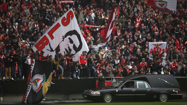 Ein Leichenwagen fährt an einer Tribüne voller Benfica Lissabon-Fans vorbei.