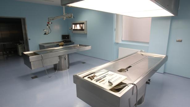 Ein heller Raum mit zwei Edelstahltischen und medizinischen Instrumenten.