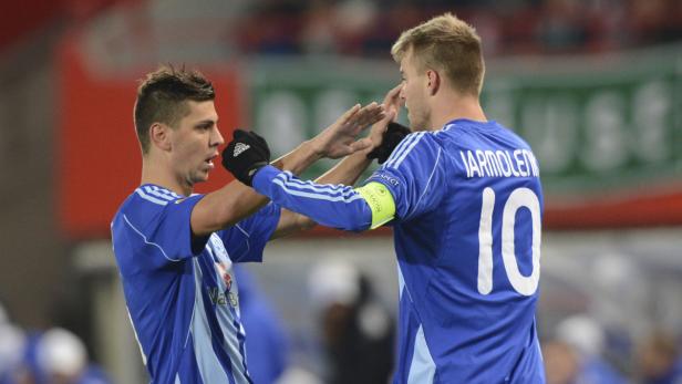 Zwei Fußballspieler in blauen Trikots geben sich ein High-Five.