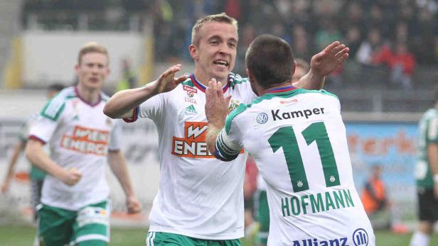 Zwei Fußballspieler von Rapid Wien feiern ein Tor.