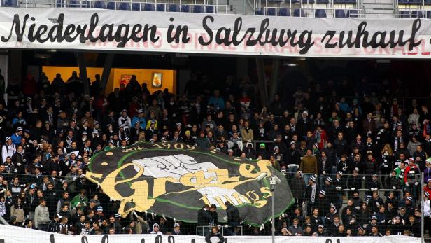 Fußballfans halten Spruchbänder im Stadion hoch.