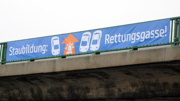Ein blaues Banner wirbt für die Bildung einer Rettungsgasse bei Stau.