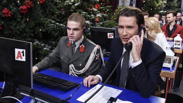 Ein Mann im Anzug telefoniert neben einem Soldaten vor einem Weihnachtsbaum.