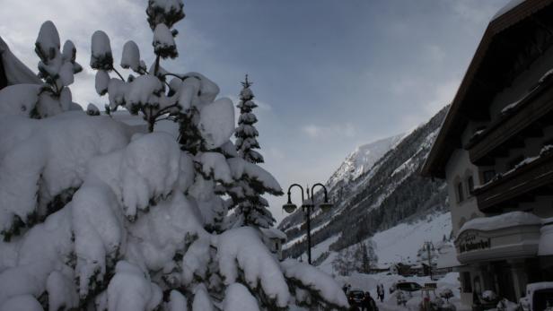 Verschneite Bäume und ein Hotel in einer Winterlandschaft.