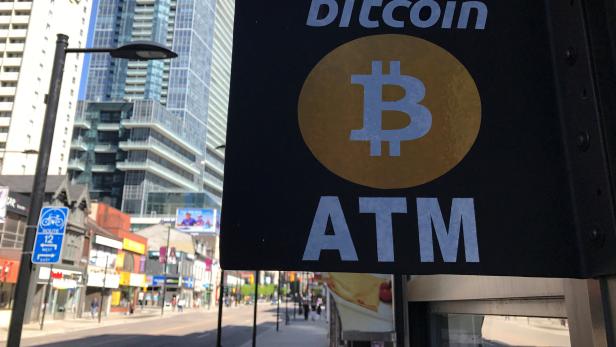 FILE PHOTO: A sign is seen outside a business where a Bitcoin ATM is located in Toronto
