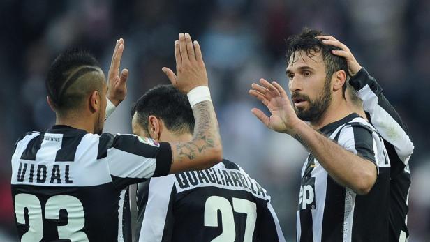 Drei Juventus-Spieler feiern auf dem Spielfeld.