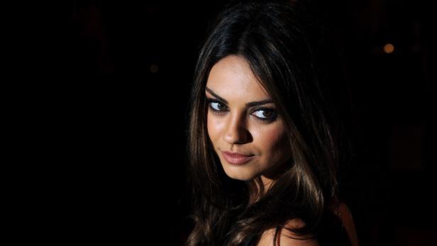 Porträt von Mila Kunis vor einem dunklen Hintergrund.