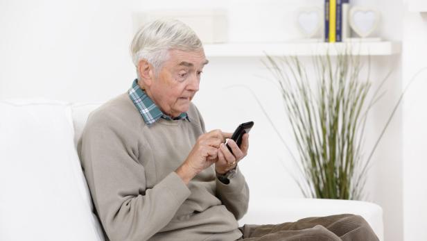 Senior Man Reading A Shocking Message On His Smart Phone