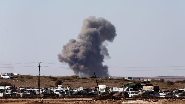 Eine Rauchsäule steigt über einem Schrottplatz auf.
