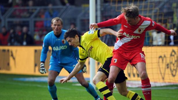 Fußballspieler kämpfen um den Ball vor dem Tor.