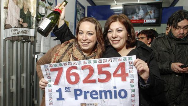 Zwei Frauen feiern mit einer Champagnerflasche und einem Los mit der Nummer 76254, dem 1. Preis.