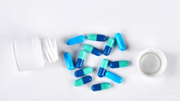 Blue medical capsules and white bottle.