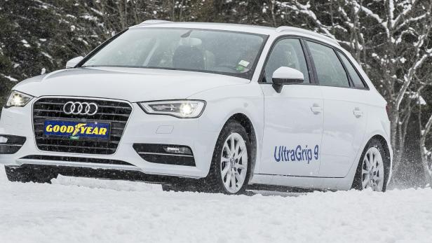 Ein weißer Audi A3 fährt auf einer schneebedeckten Straße.