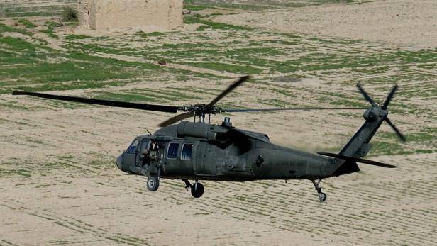 Ein Black Hawk Hubschrauber der US Army im Flug über ein Feld.
