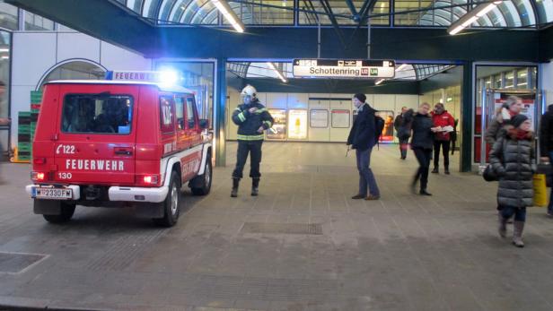 Ein Feuerwehrmann steht vor einem roten Feuerwehrfahrzeug am U-Bahnhof Schottenring.