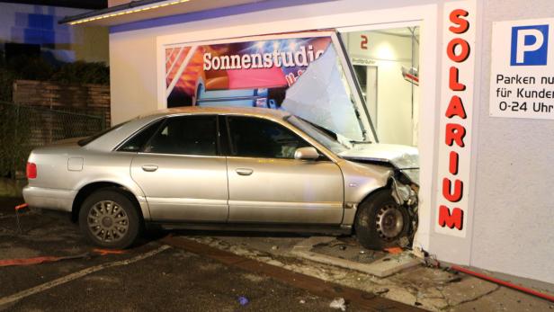 Ein silbernes Auto ist in die Fassade eines Sonnenstudios gefahren.