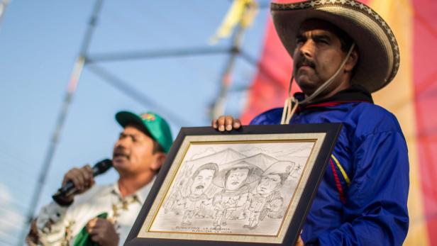 epa03653394 Venezuelan Interim President and presidential candidate shows a drawing given by leaders of Indonesia´s International Peasant Movement, during an electoral campaign act in San Juan de los Morros, Venezuela, 07 April 2013. Elections in the country will be held on next 14 April 2013. EPA/MIGUEL GUTIERREZ