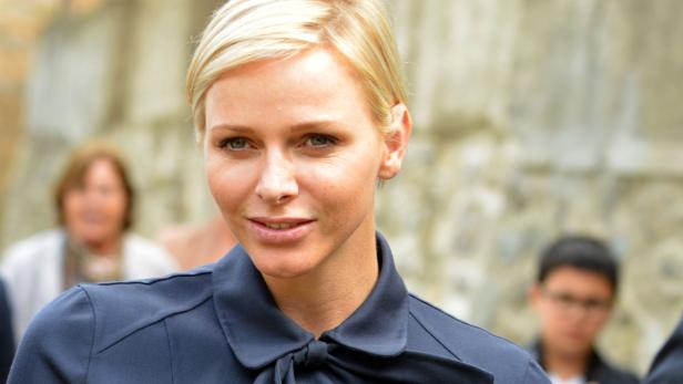 Fürstin Charlène von Monaco mit blonden, kurzen Haaren und einem dunkelblauen Oberteil.