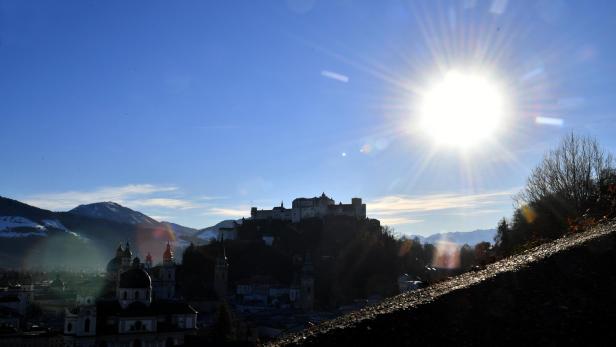Die Festung Hohensalzburg überragt die Stadt Salzburg unter strahlendem Sonnenschein.