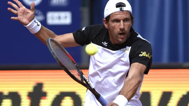 Ein Tennisspieler schlägt einen Ball mit seinem Schläger.