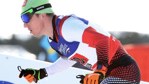 Ein Langläufer in rot-weißer Sportbekleidung während eines Rennens.