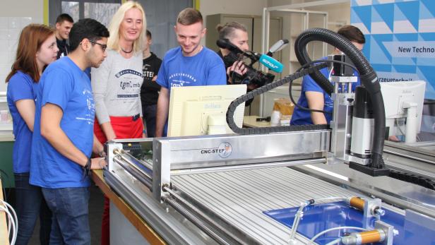 Schüler_innen und Lehrerin/Abteilungsvorständin vor Station 2, dem Ausfräs-Automaten