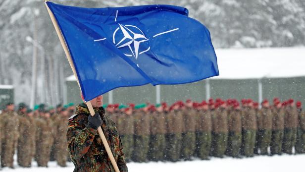 A soldier carries the NATO flag during German Minister of Defence Ursula von der Leyen's visit to German troops deployed as part of NATO enhanced Forward Presence (eFP) battle group in Rukla military base