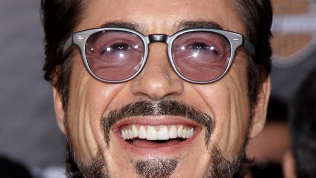 Robert Downey Jr. lächelt mit Brille und Bart in die Kamera.