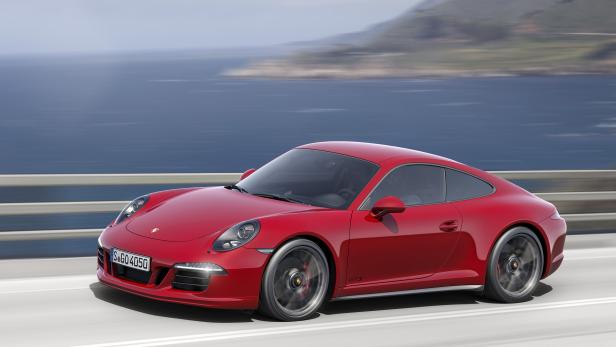Ein roter Porsche 911 GTS fährt auf einer Küstenstraße.